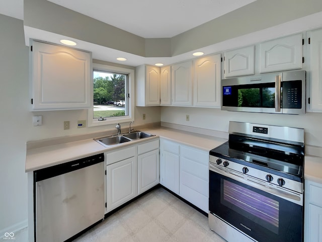 kitchen with sink, stainless steel appliances, white cabinets, and light tile patterned floors