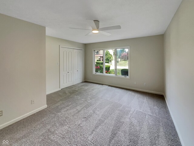 empty room featuring ceiling fan and carpet