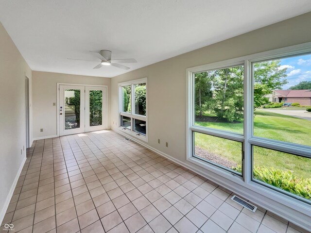 unfurnished living room with ceiling fan, light tile patterned floors, and french doors