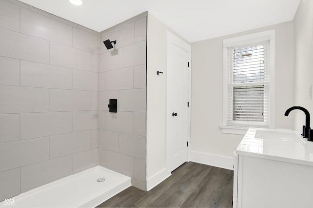 bathroom with vanity, hardwood / wood-style flooring, and a tile shower