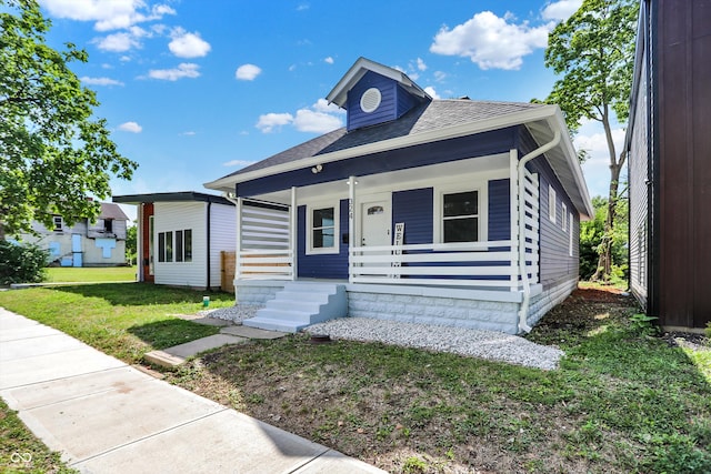 view of front facade featuring covered porch and a front yard