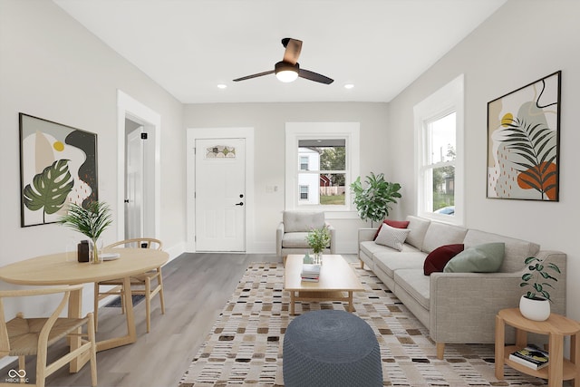 living area featuring light wood-style flooring, baseboards, a ceiling fan, and recessed lighting