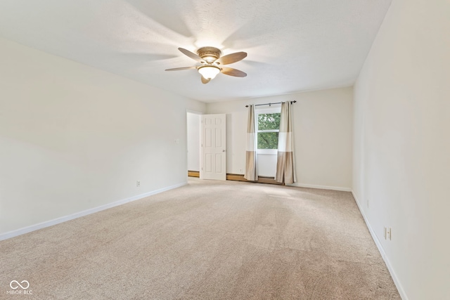 carpeted empty room featuring ceiling fan and baseboard heating