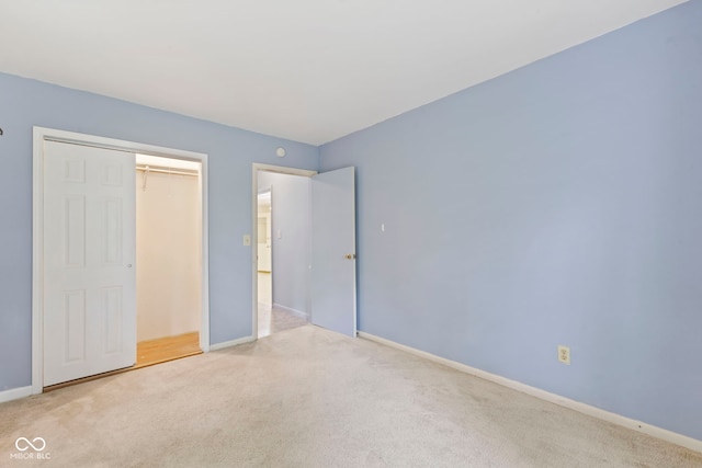 unfurnished bedroom featuring light carpet and a closet