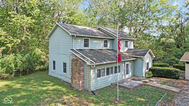 rear view of property with a yard