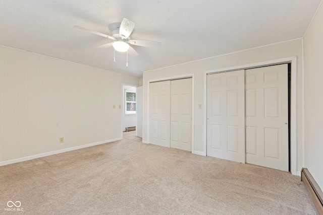 unfurnished bedroom featuring multiple closets, a baseboard radiator, light colored carpet, and ceiling fan