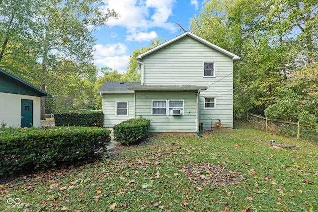 rear view of property featuring a lawn