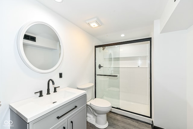 bathroom featuring vanity, wood finished floors, recessed lighting, a shower stall, and toilet