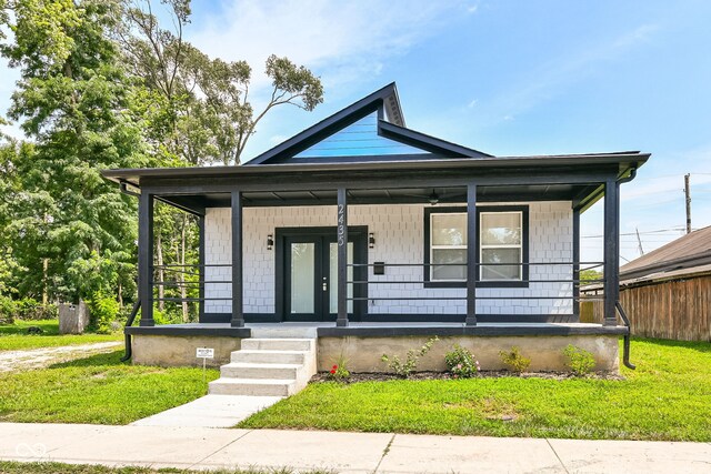 view of front of house featuring covered porch and a front yard