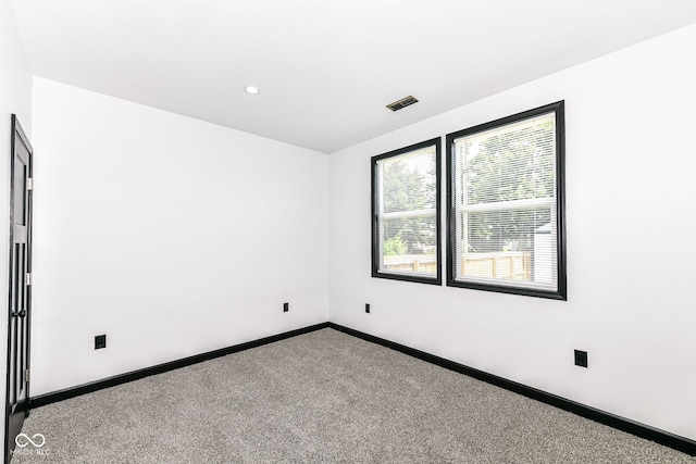 spare room with visible vents, recessed lighting, carpet, and baseboards