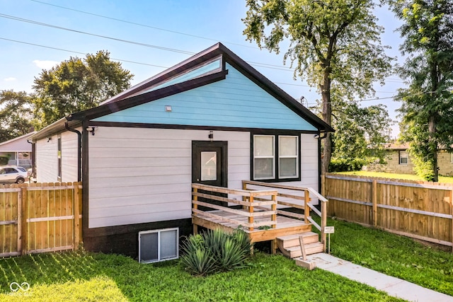 back of house featuring a yard, fence, and a wooden deck