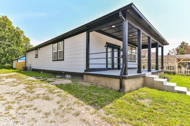 view of property exterior featuring cooling unit and a yard