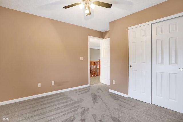 unfurnished bedroom with ceiling fan, a closet, and light carpet