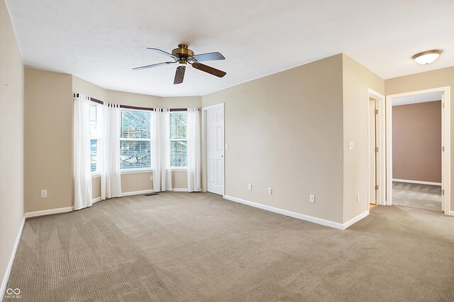 carpeted spare room featuring ceiling fan