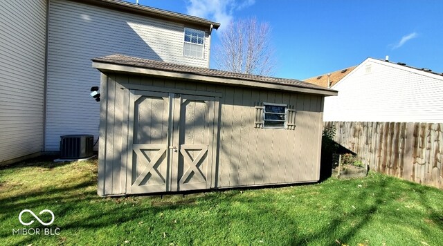 view of outbuilding with a lawn and central air condition unit