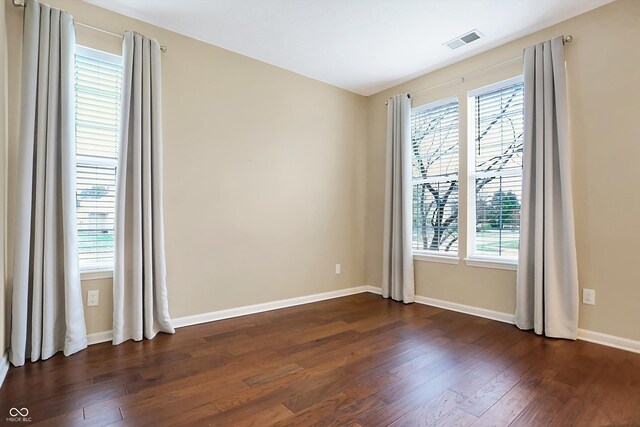 unfurnished room featuring dark hardwood / wood-style floors and a healthy amount of sunlight