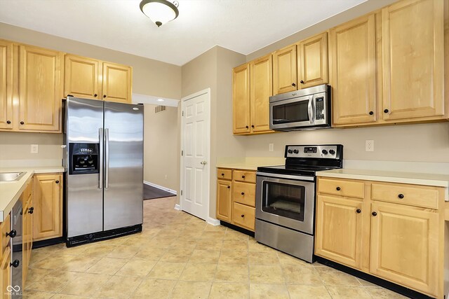 kitchen with appliances with stainless steel finishes and light brown cabinets