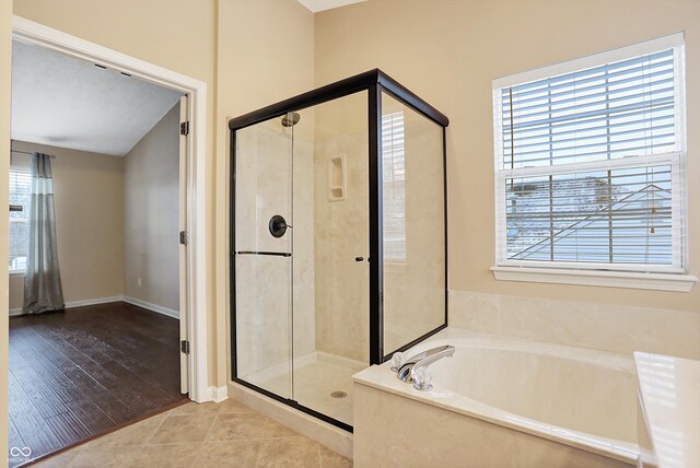 bathroom with separate shower and tub and wood-type flooring