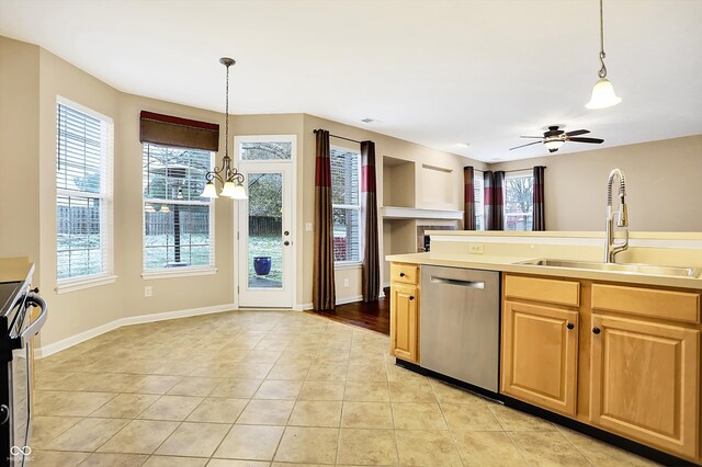 kitchen featuring ceiling fan with notable chandelier, stainless steel appliances, sink, light tile patterned floors, and decorative light fixtures