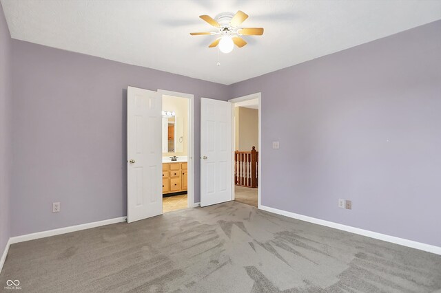 unfurnished bedroom featuring ensuite bath, ceiling fan, and light colored carpet