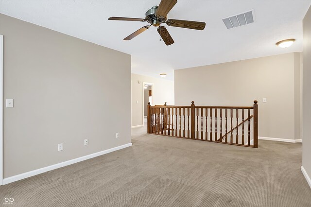 carpeted spare room featuring ceiling fan