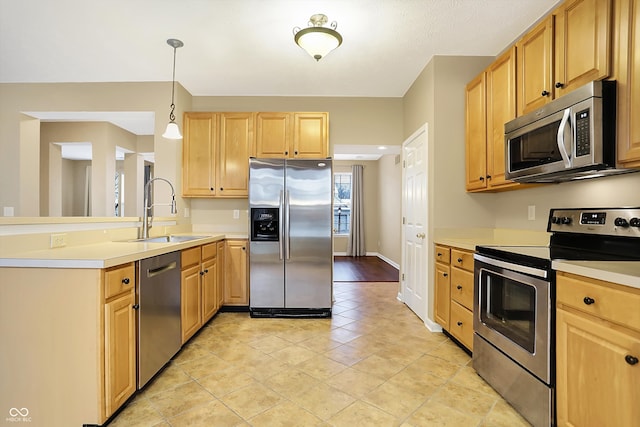 kitchen featuring pendant lighting, light brown cabinets, sink, light hardwood / wood-style flooring, and stainless steel appliances