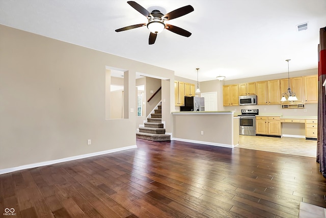 unfurnished living room with ceiling fan with notable chandelier and dark wood-type flooring