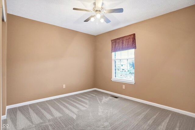 carpeted spare room with ceiling fan and a textured ceiling