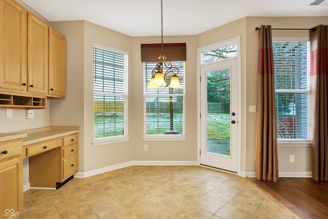 doorway featuring built in desk and light hardwood / wood-style floors