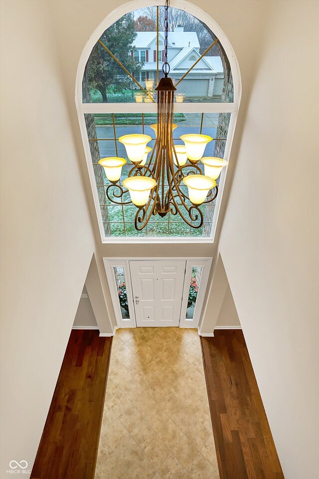 foyer entrance featuring a chandelier, a high ceiling, and hardwood / wood-style flooring