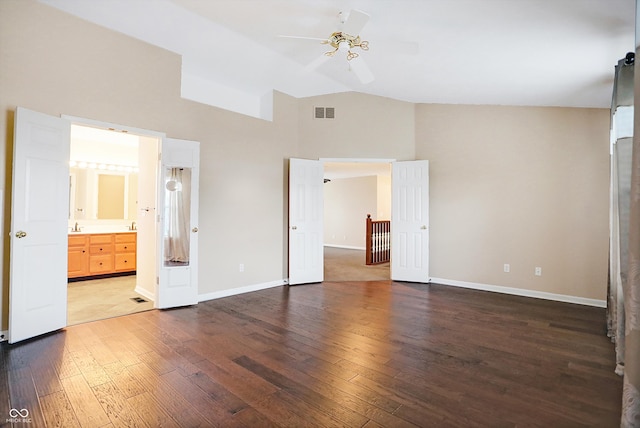 unfurnished bedroom with ensuite bath, ceiling fan, high vaulted ceiling, and dark wood-type flooring