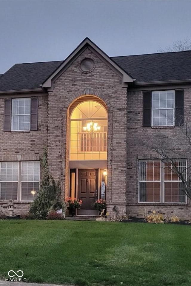 exterior entry at dusk with a lawn