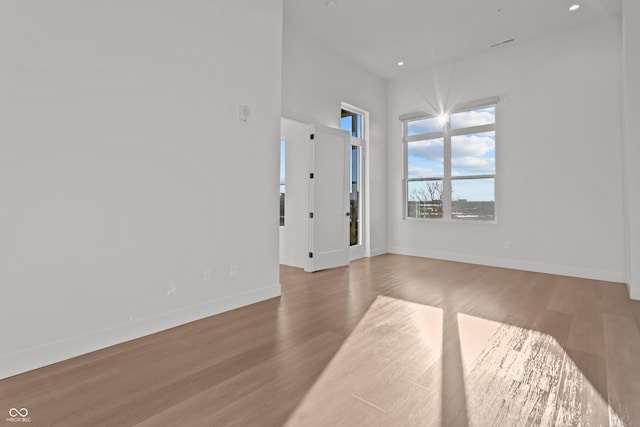 spare room with recessed lighting, baseboards, and wood finished floors