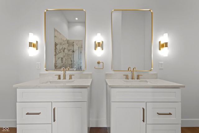 bathroom with a stall shower, two vanities, and a sink