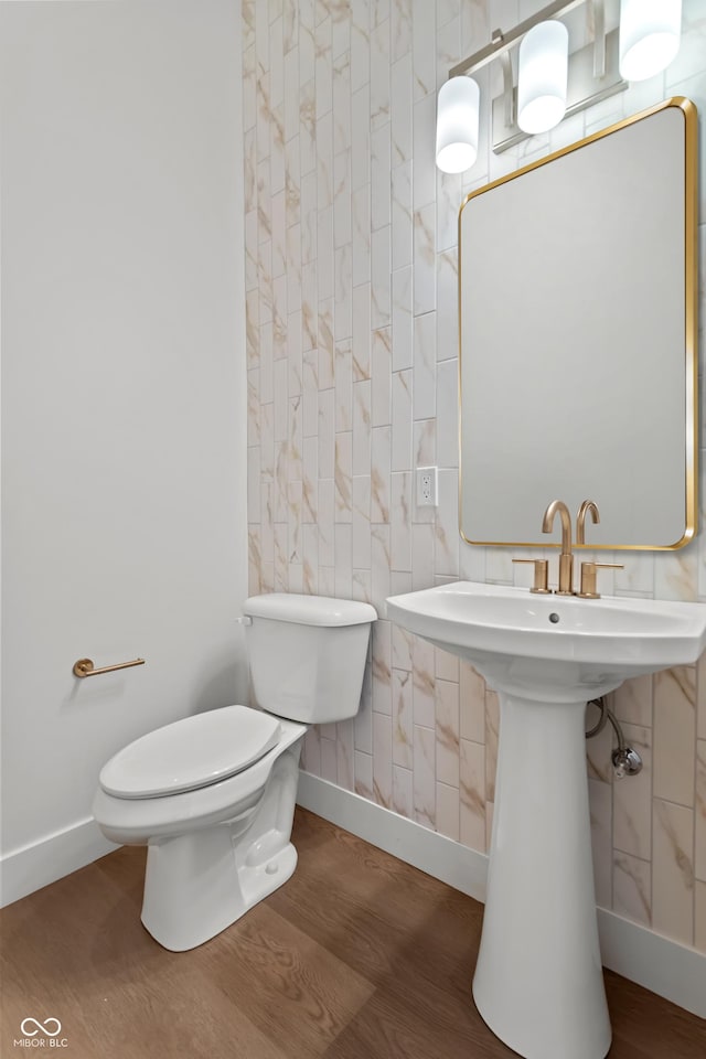 bathroom featuring toilet, baseboards, and wood finished floors