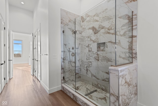 full bathroom featuring recessed lighting, wood finished floors, baseboards, and a walk in shower