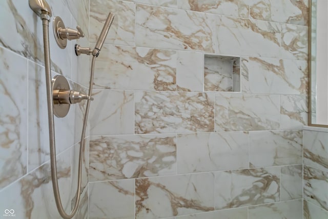 interior details featuring a tile shower