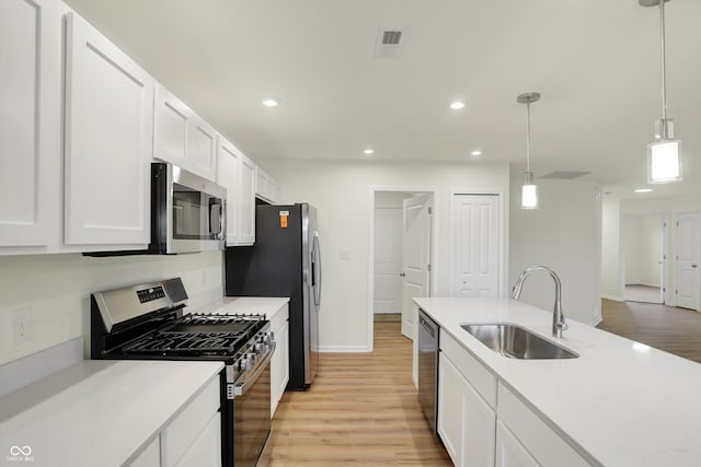 kitchen featuring light hardwood / wood-style floors, sink, pendant lighting, and appliances with stainless steel finishes