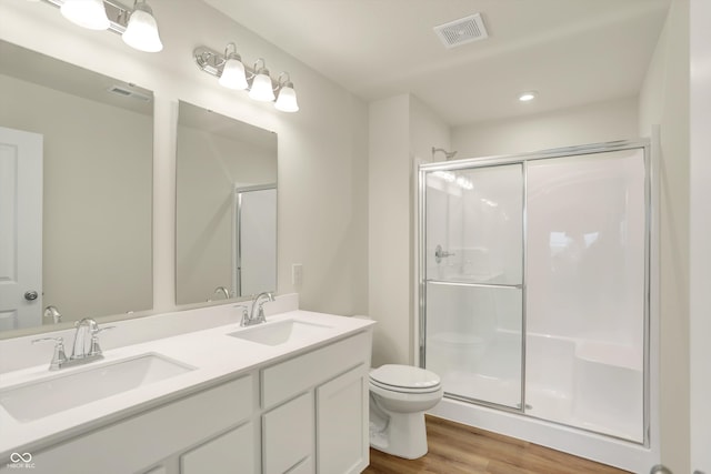 bathroom featuring walk in shower, wood-type flooring, toilet, and vanity