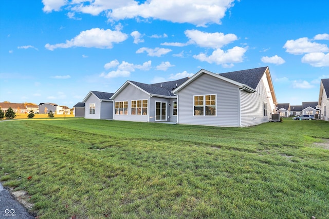 back of house with central AC and a lawn