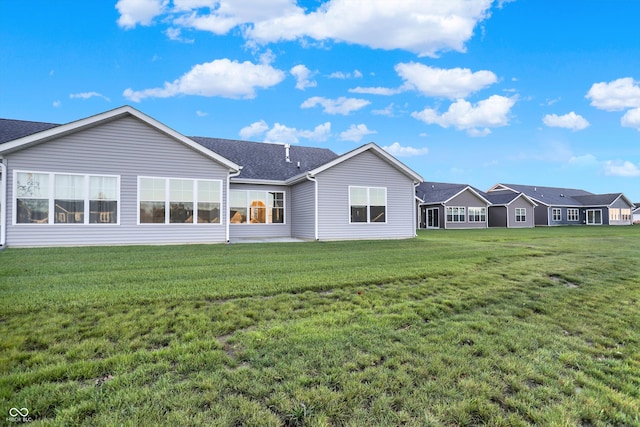 rear view of house featuring a lawn