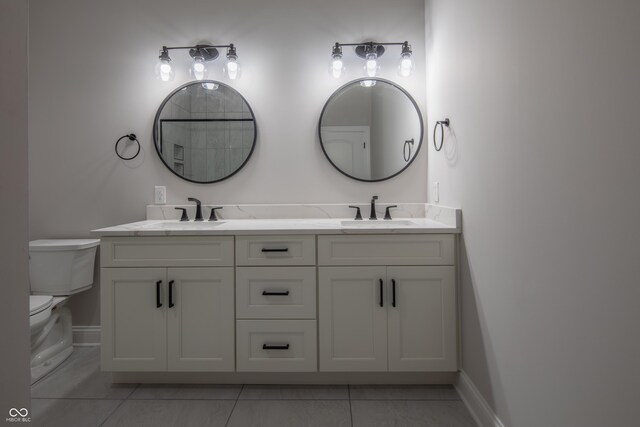 bathroom featuring tile patterned floors, dual vanity, and toilet