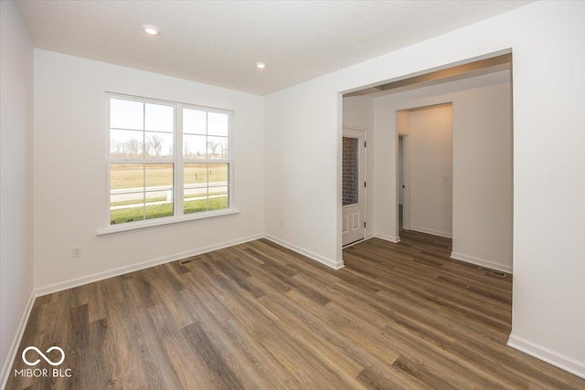 unfurnished room featuring dark wood-type flooring