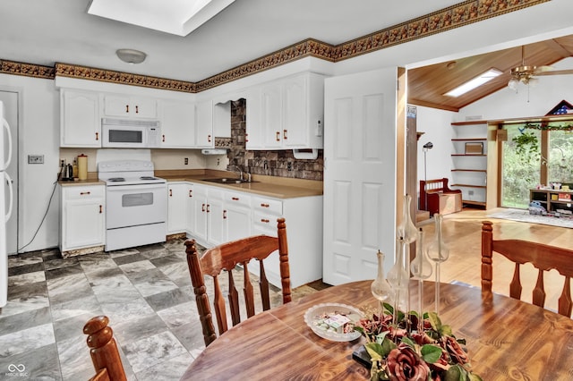 kitchen with white cabinets, a sink, white appliances, tasteful backsplash, and ceiling fan
