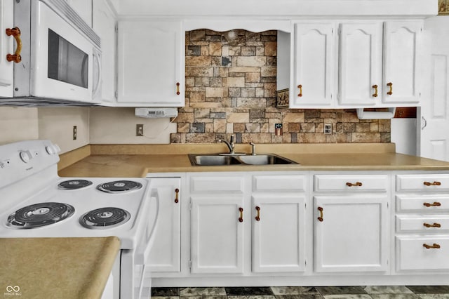 kitchen with white cabinets, a sink, and white appliances