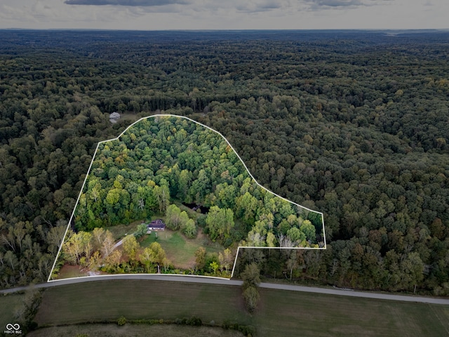 birds eye view of property featuring a view of trees