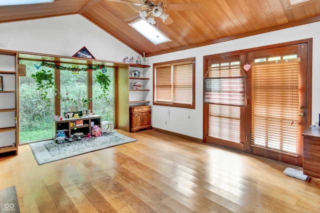 interior space featuring light wood-type flooring, ceiling fan, wooden ceiling, and vaulted ceiling with skylight