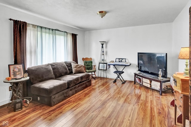 living area with light wood-style floors and baseboards