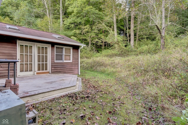 view of yard with a forest view and a wooden deck