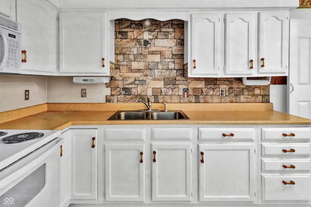 kitchen with decorative backsplash, sink, white cabinets, and white appliances